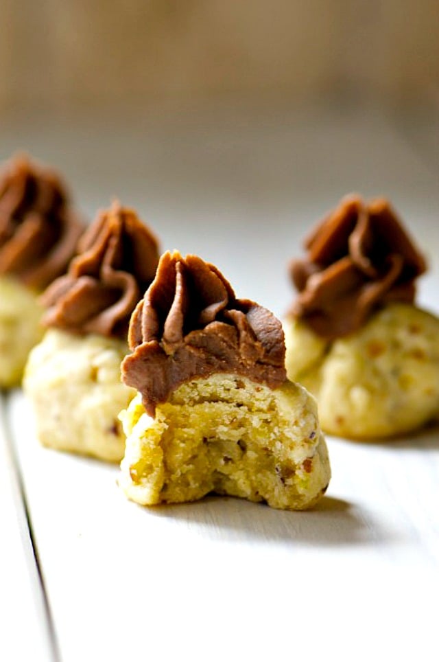 A close-up of a chocolate-topped shortbread cookie with a bite taken out.