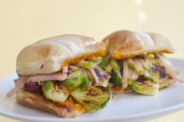 Two halves of the Brussels Sprout Sandwich on a white plate.