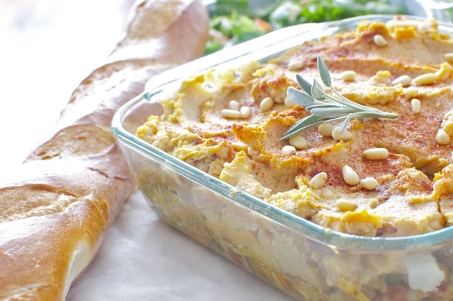 A casserole dish holds Shepherd's Pumpkin Pie/ Beside it is a long roll of french bread.