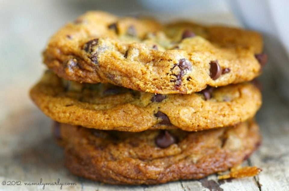 A stack of three orange chocolate chip cookies.