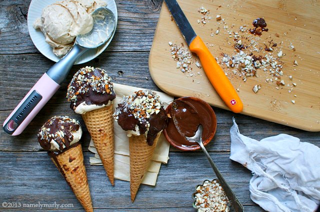 Looking down on several frozen drumsticks coated in chocolate and chopped nuts.