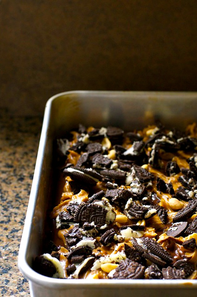 Crumbled Oreo cookies have been spread over a pan full of brownies.