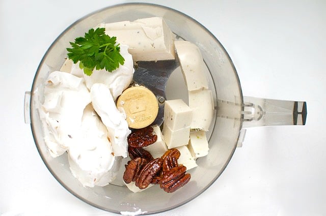 Ingredients for a vegan cheese ball are in a food processor, waiting to be pulsed.