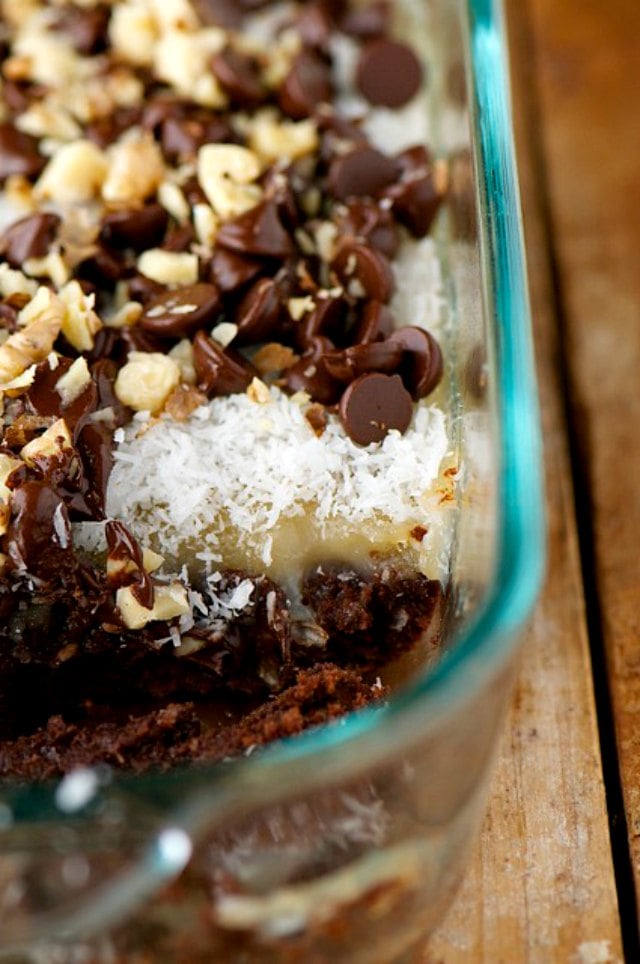 Looking into a 9X13 baking dish full of brownie magic bars with a slice removed, showing lots of vegan condensed milk.