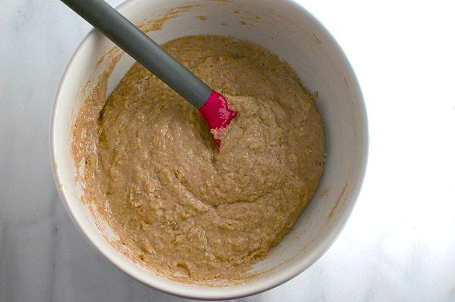 Looking down on a white bowl with batter in it. There is a spatula in the batter.