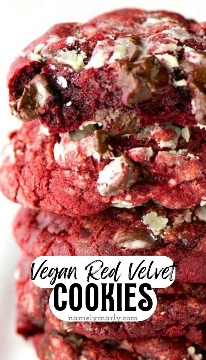 Stack of vegan red velvet cookies with chocolate chips and a textured surface, topped with white chunks.