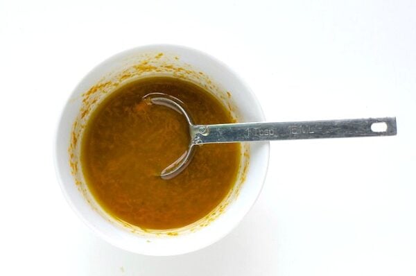 A dark sauce is in a bowl with a spoon.