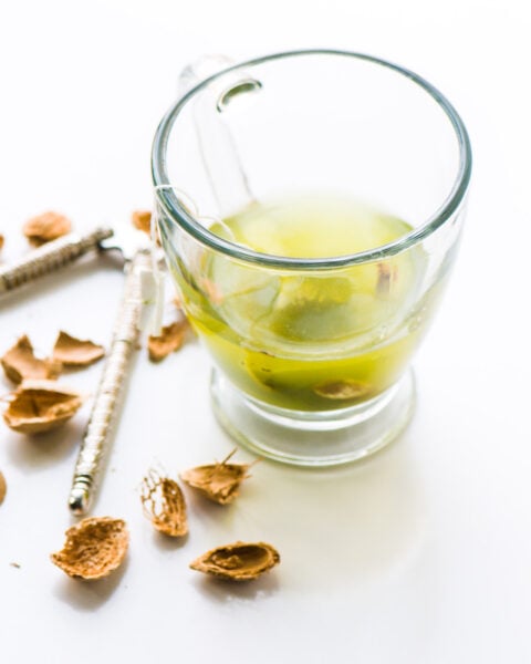 A photo of a glass mug holding a green tea bag.