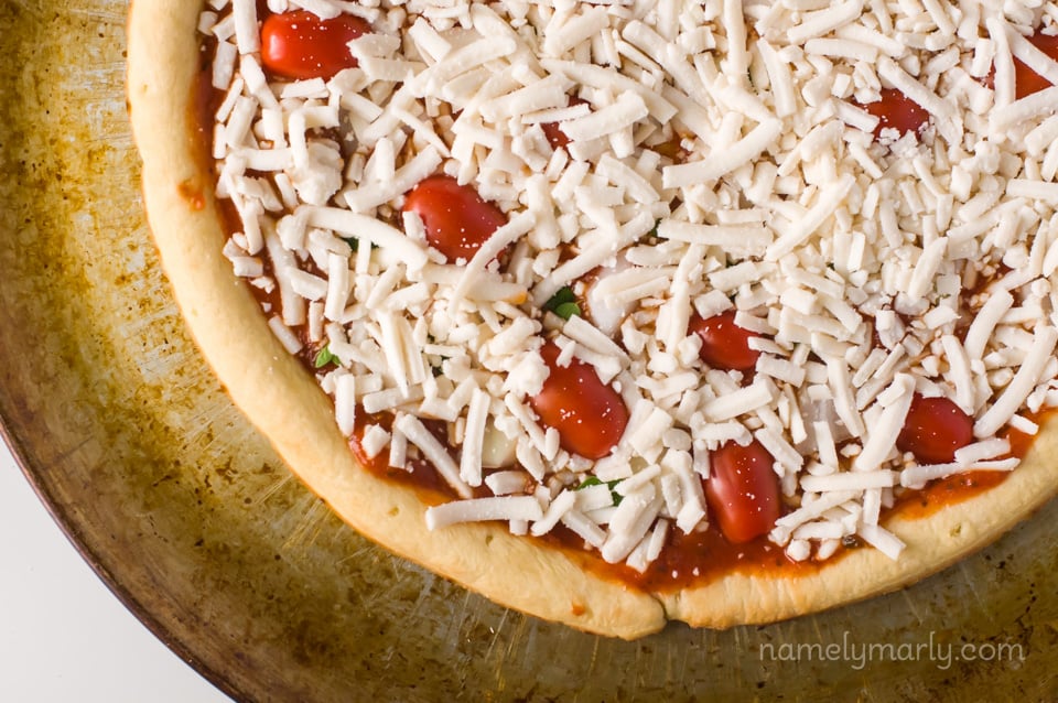 Looking down on an unbaked pizza on a metal pizza pan.
