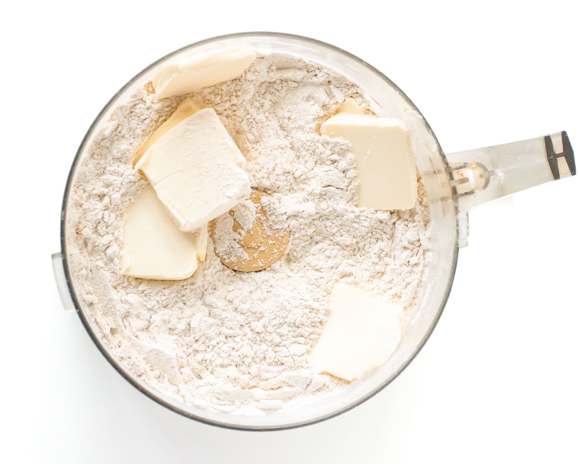Flour and vegan butter in a food processor bowl.