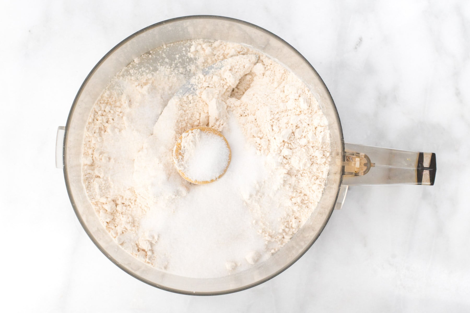 The ingredients for a vegan pie crust are in a food processor