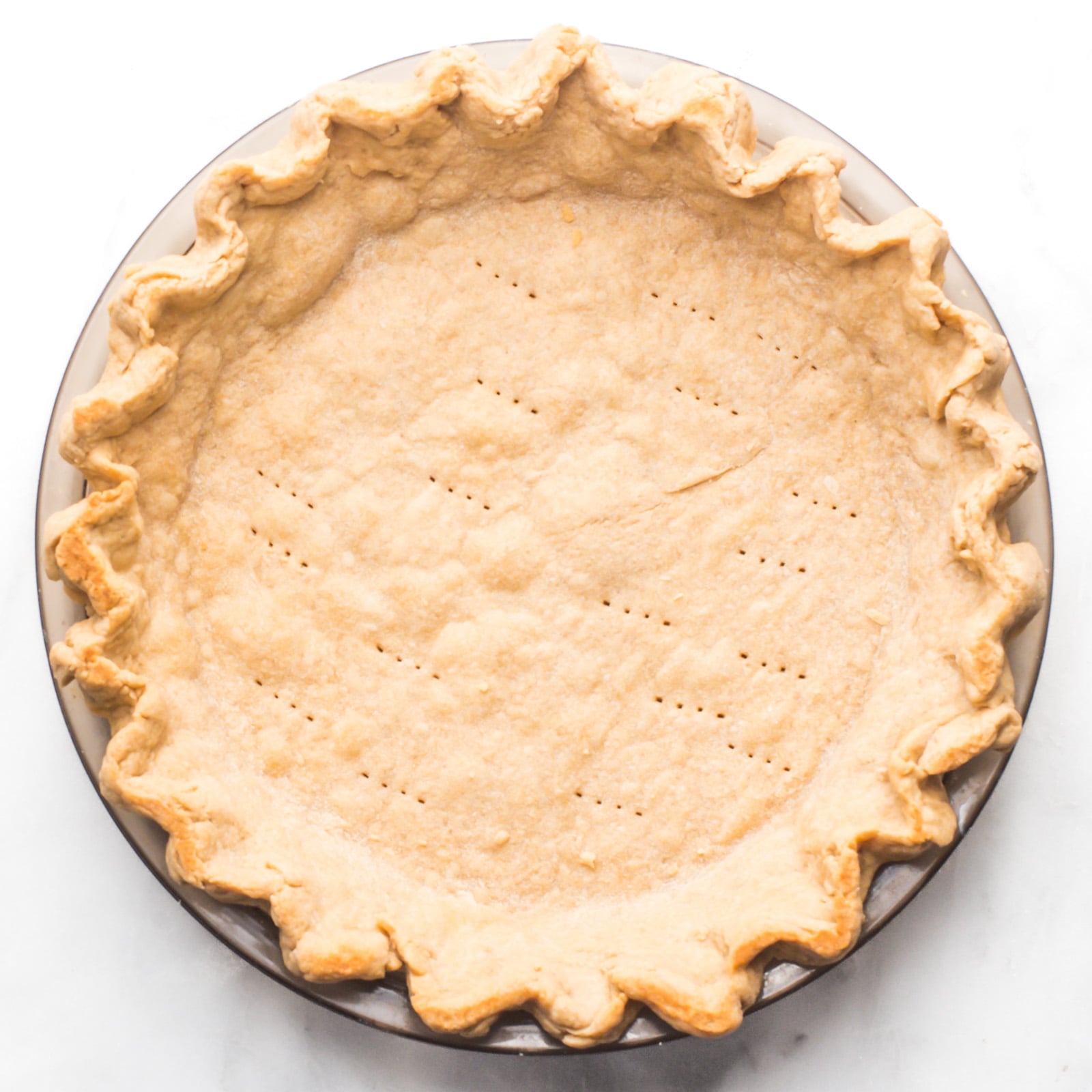A baked pie crust in a pie pan.