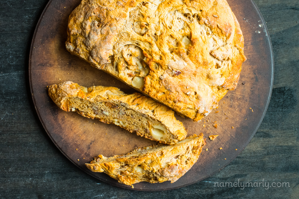 Looking down on a rustic round loaf of bread with a couple of slices cut off.