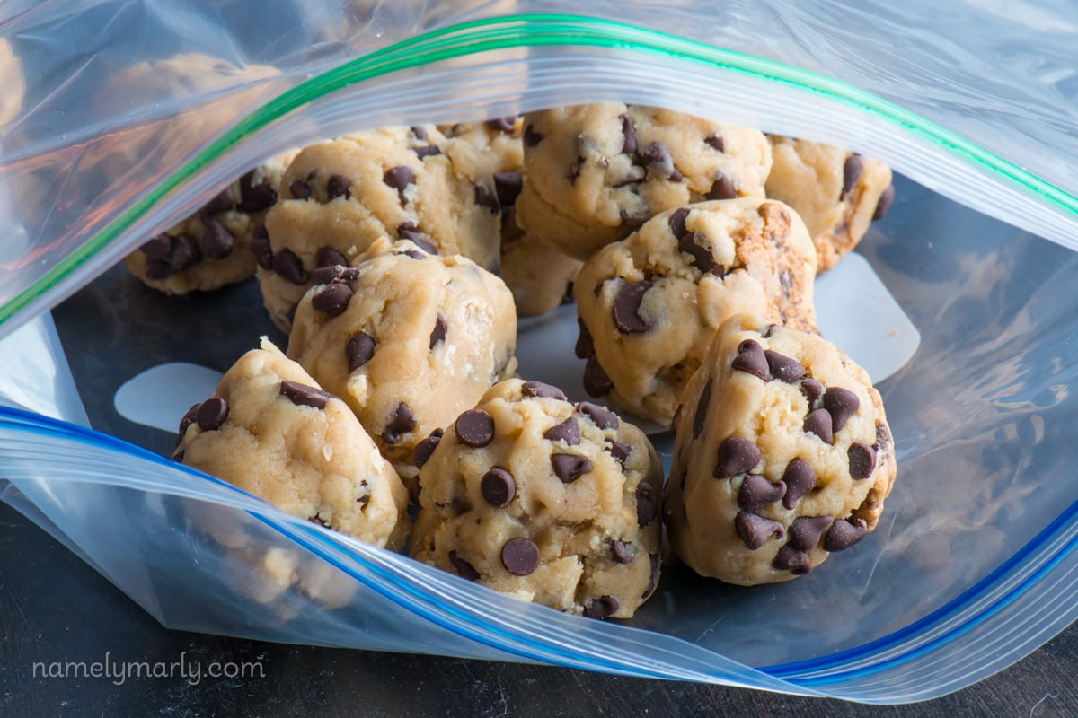 Several frozen cookie dough balls are in a freezer bag.