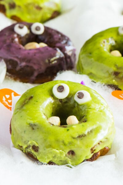 Purple and green donuts with googly eyes for Halloween.