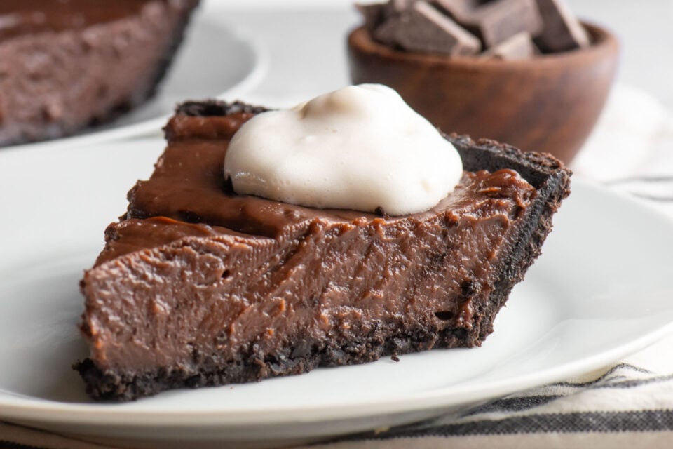 A slice of vegan chocolate peanut butter pie on a white plate.