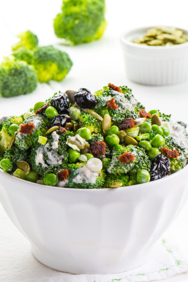 This Vegan Broccoli Salad is made with lightly steamed broccoli, pumpkin seeds, cranberry raisins, and vegan bacon pieces. You're going to love the lightly sweet dressing as well. It's a perfect salad for your next family gathering or party!