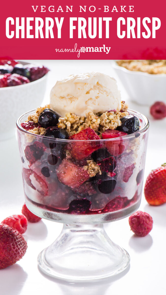 A bowl of vegan no-bake cherry fruit crisp in a serving dish with ice cream on top and other toppings behind it. Text reads vegan no-bake cherry fruit crisp.