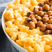 Closeup of Vegan Stovetop Mac and Cheese with Smoky Chickpeas in a white bowl next to a blue kitchen towel
