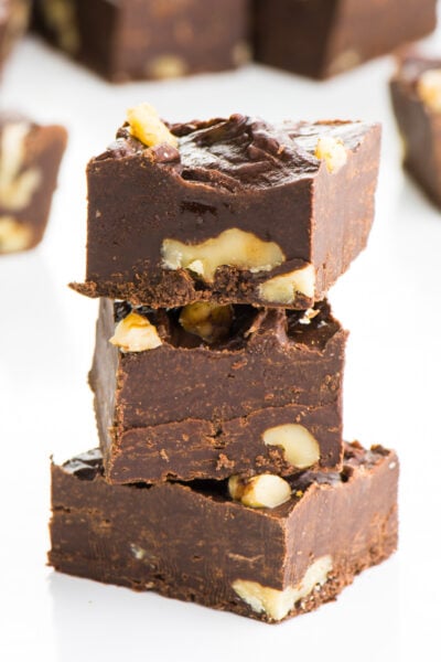 A stack of three pieces of vegan fudge sit in front of more pieces.