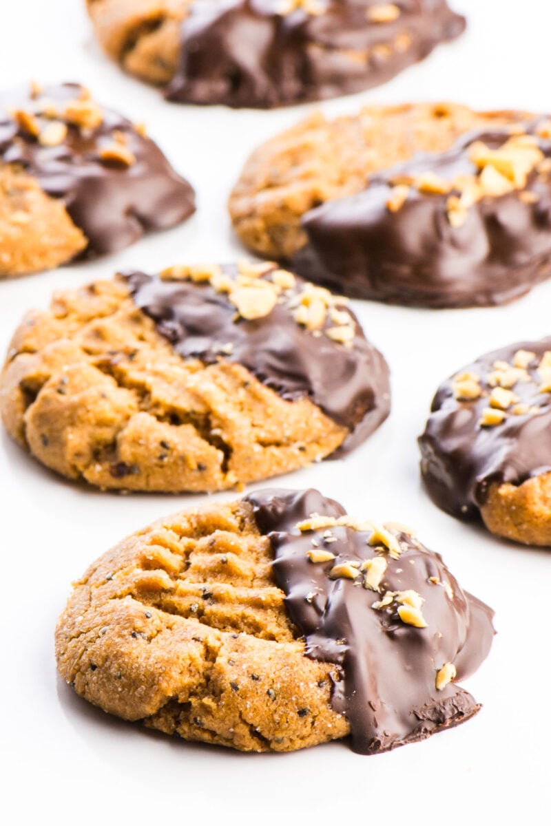 Chocolate-Dipped Peanut Butter Cookies are arranged on a platter, side by side.