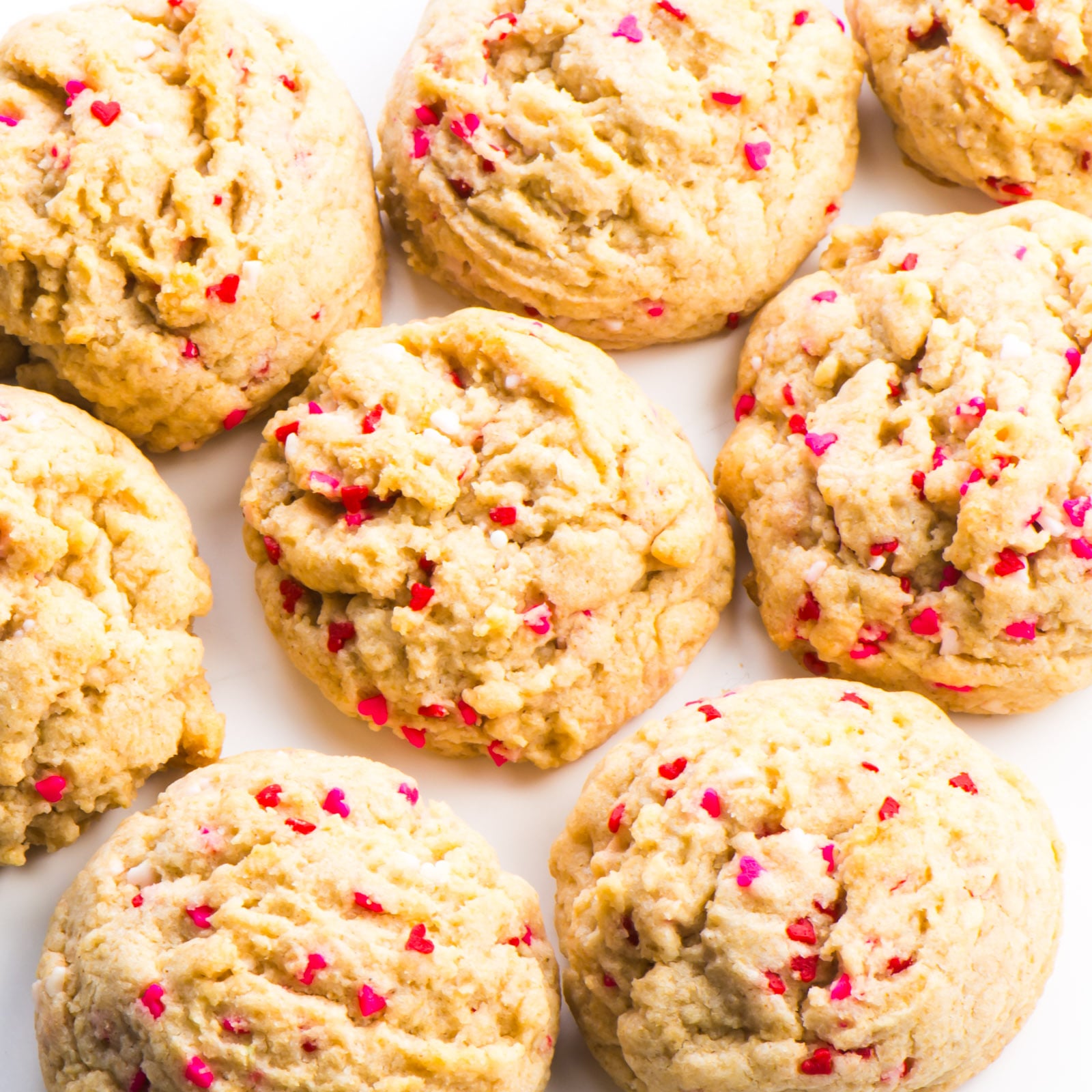 This photo looks down on a countertop where several valentines cookies are placed next too each other.