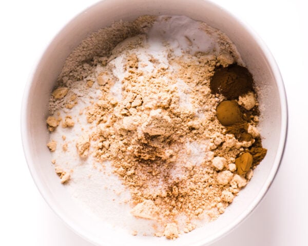 The dry ingredients for this cake are in a white mixing bowl.