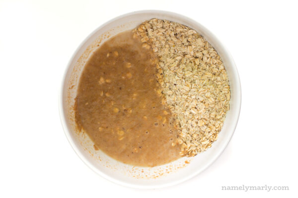 Oats have been combined with a liquid mixture in a bowl.