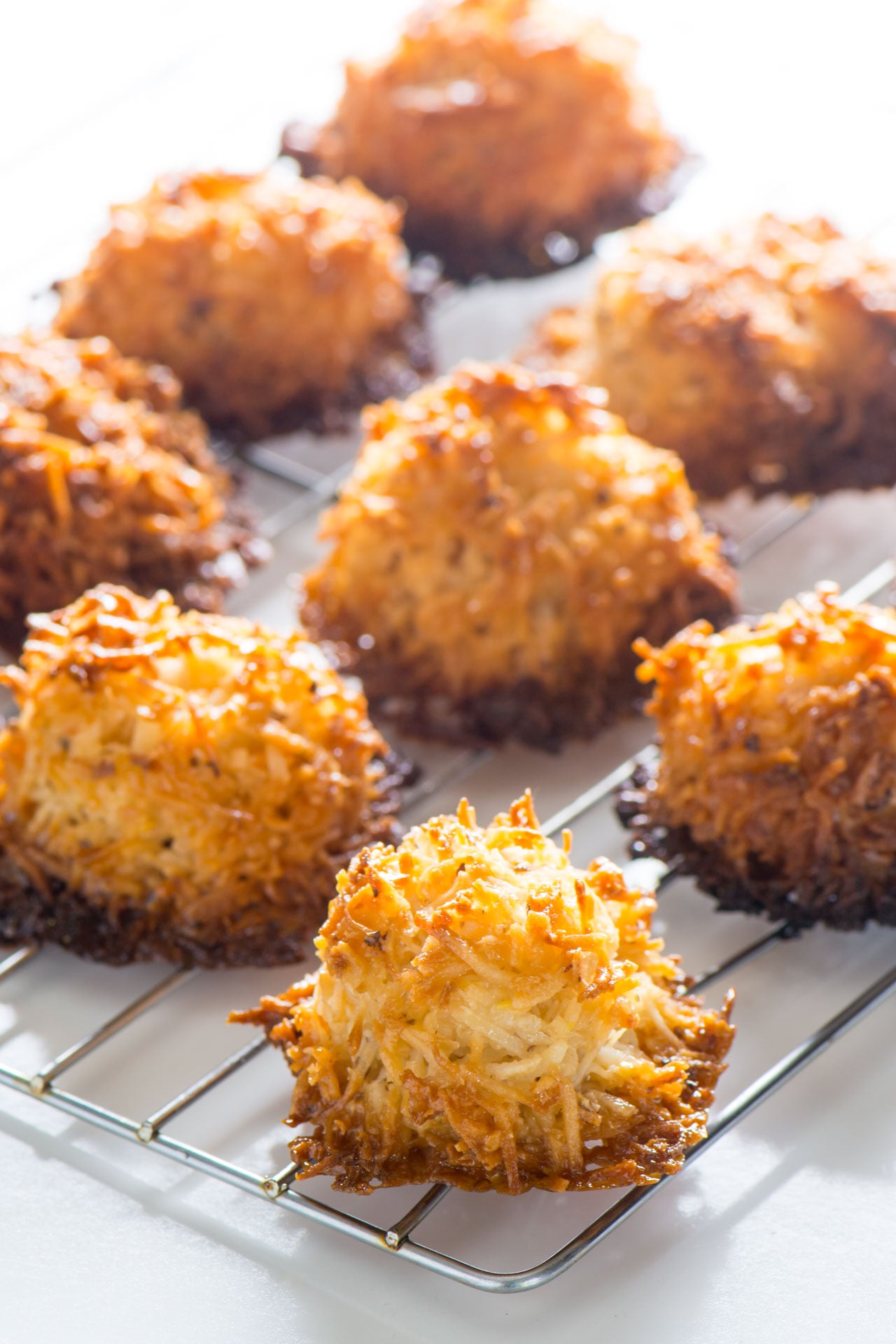 Coconut macaroons sit on a wire rack to cool.