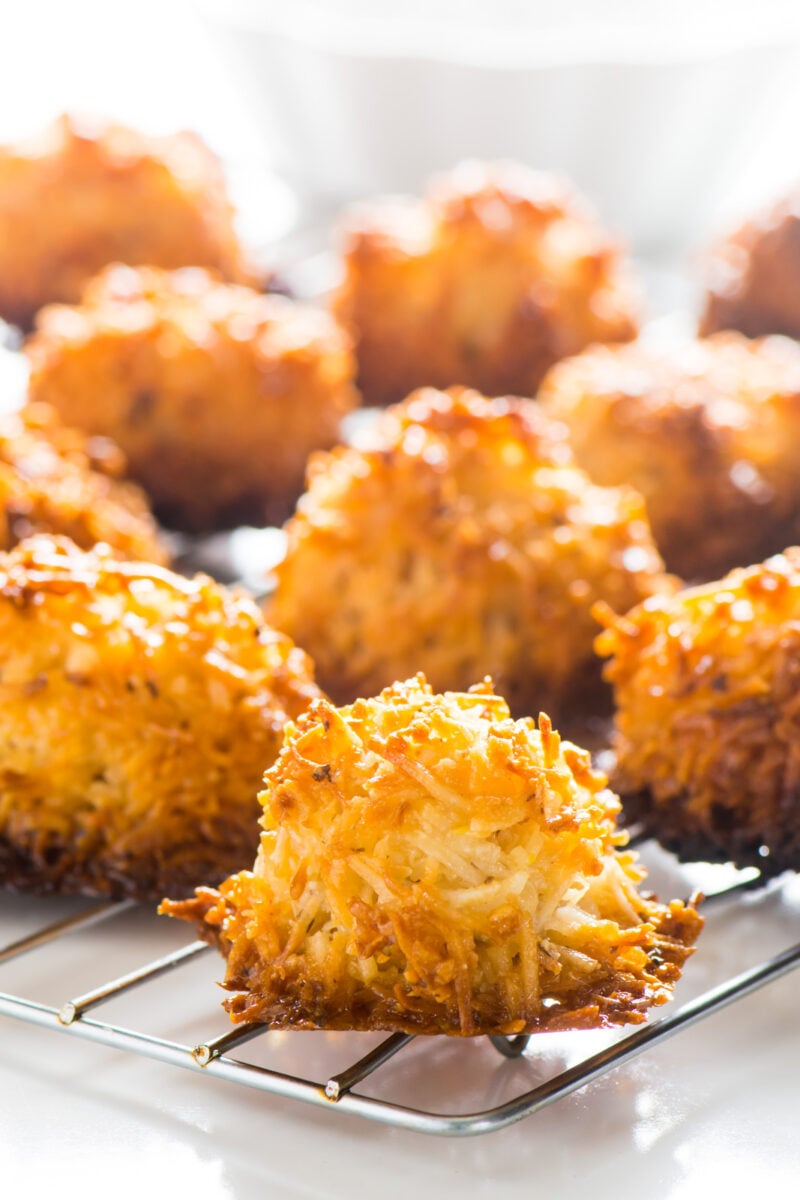 Several gluten free macaroons sit on a wire rack, cooling after being baked.
