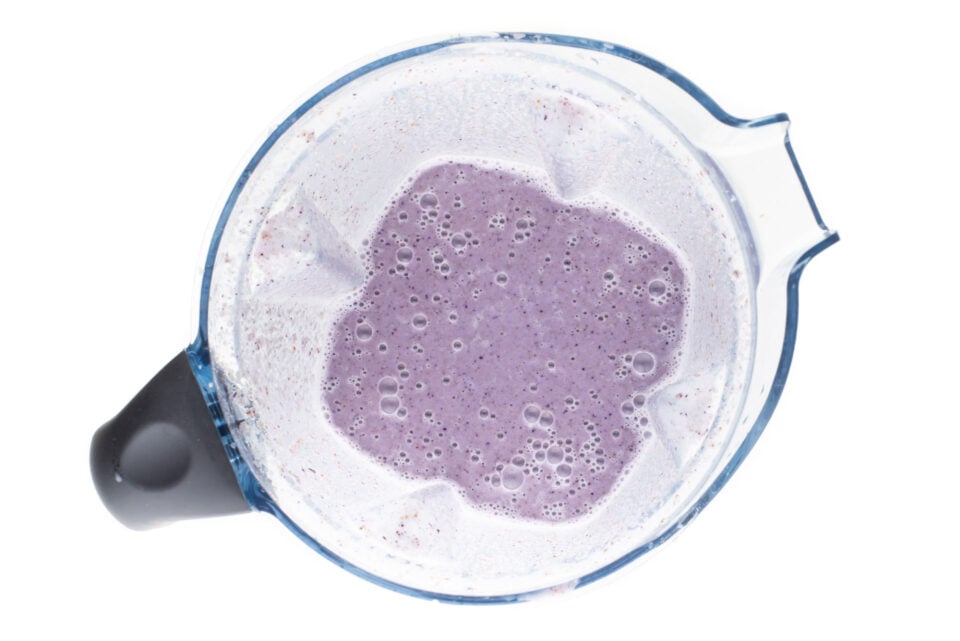 The sauce at the bottom of the blender is la purple hue because we've added fresh blueberries.