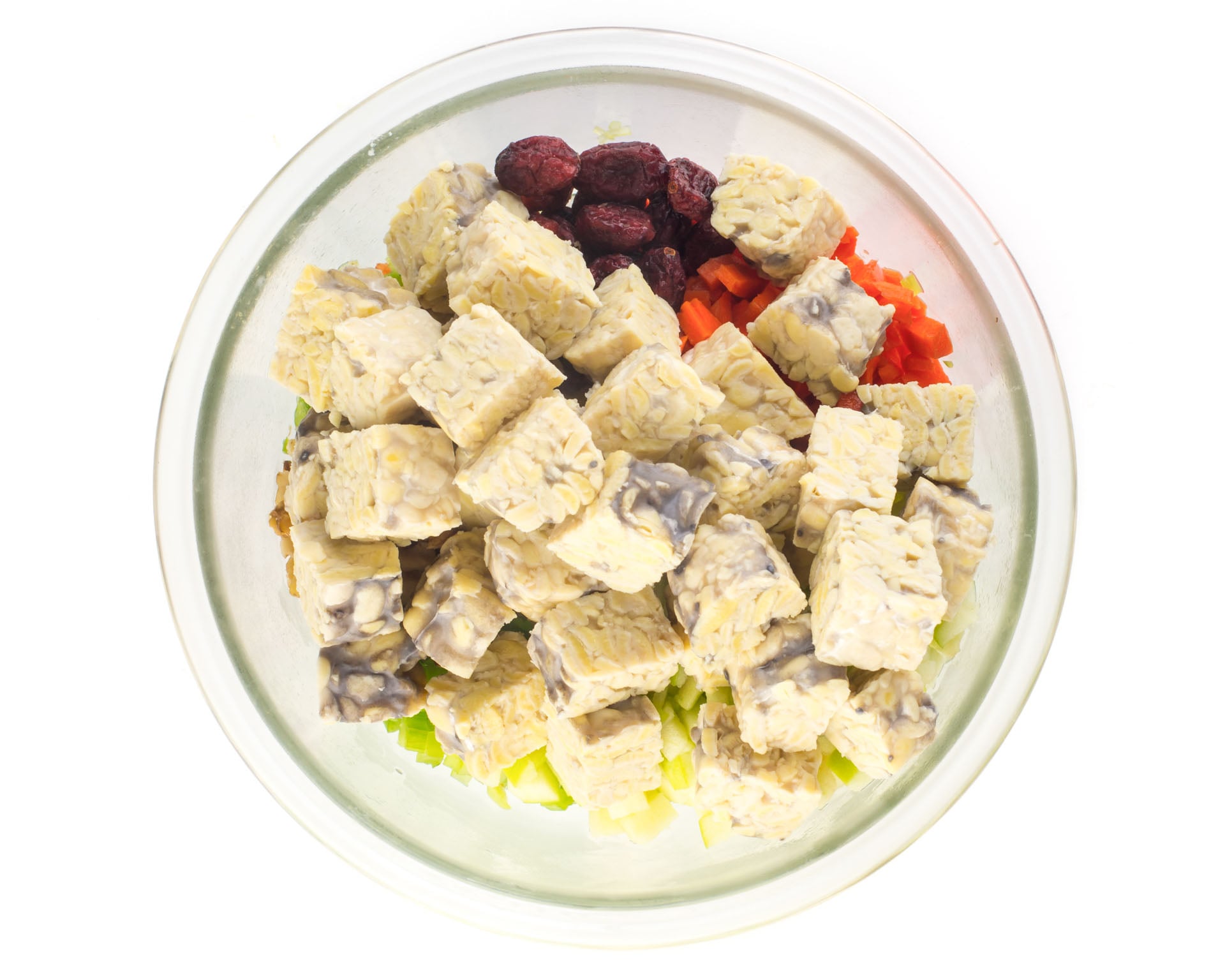 Freshly steamed tempeh cubes added to the bowl with the other ingredients.