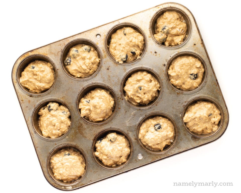 Vegan muffin dough in a muffin pan ready to go in the oven.