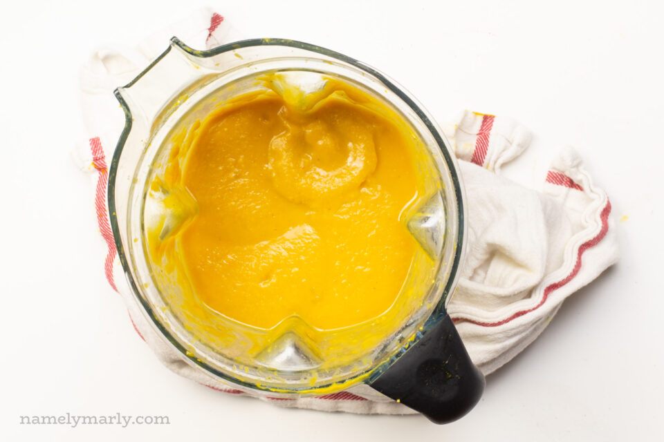 An orange squash mixture in a blender.