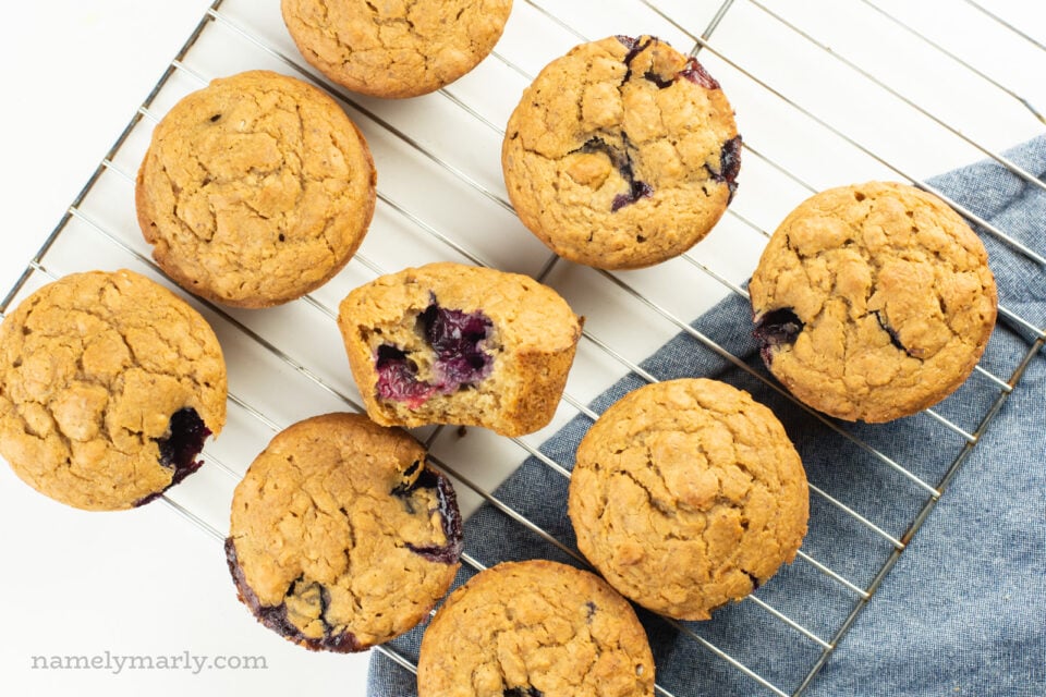 Looking down on a batch of freshly baked muffins, one with a bite taken out.