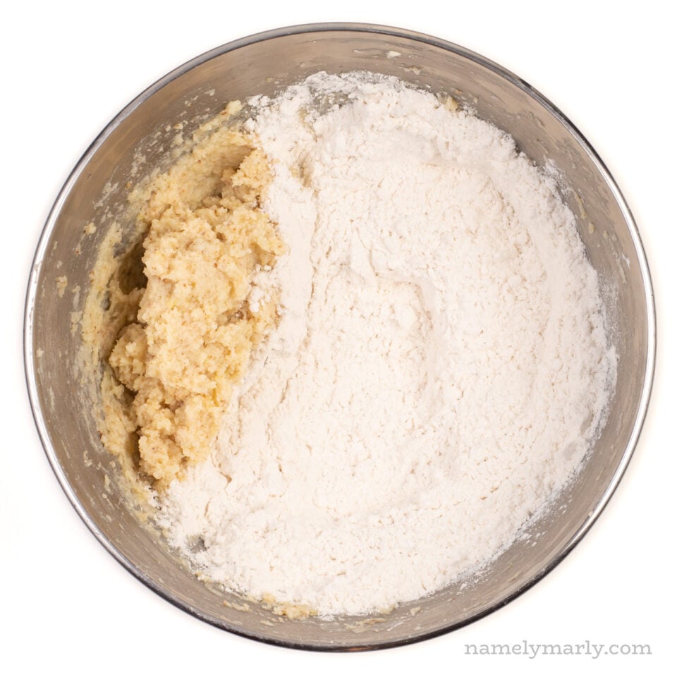 The wet ingredients are on one side of the bowl and the flour is on the other side of the bowl.