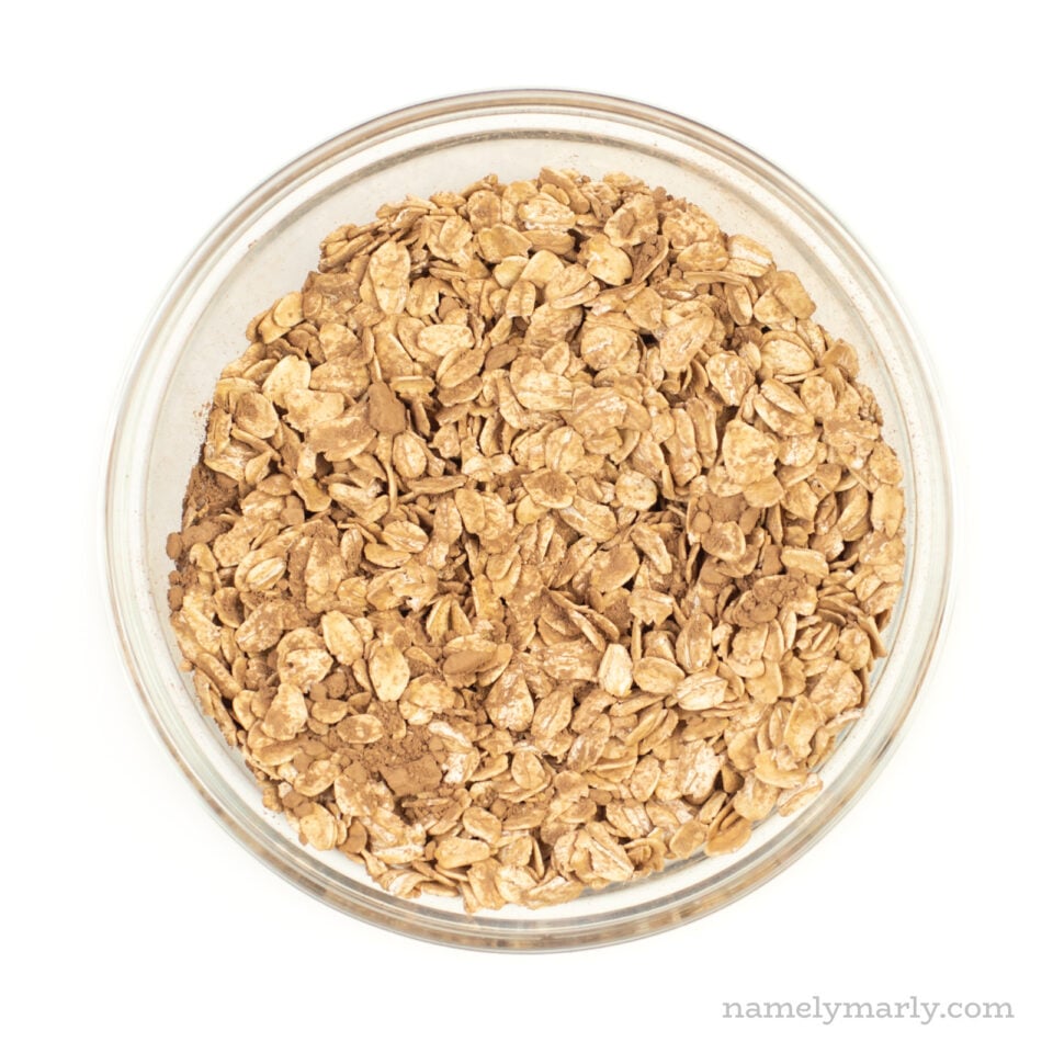 A bowl of oats mixed with cocoa powder and other ingredients.
