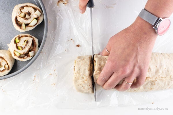 Using a serrated knife to cut cinnamon rolls.