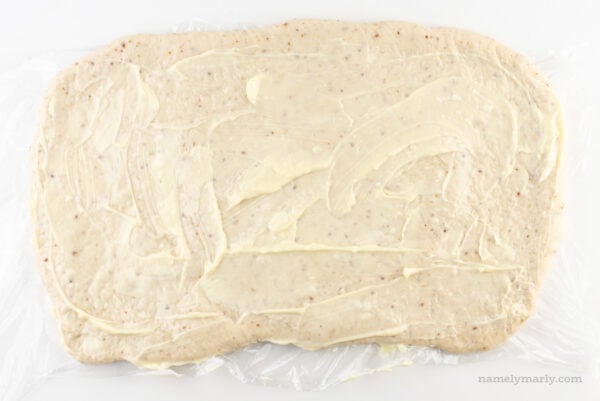 Vegan butter has been spread over dough rolled out in a rectangle.