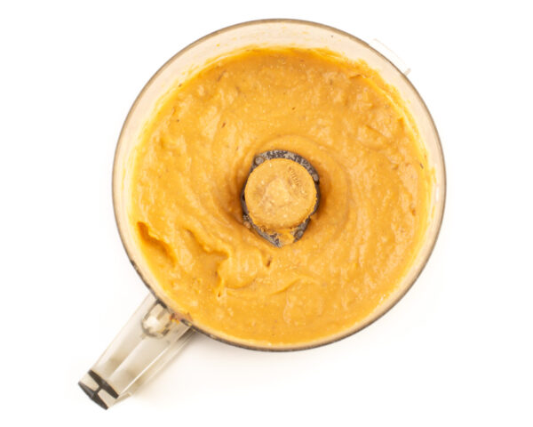 Looking down on pureed sweet potato mixture in a food processor bowl.