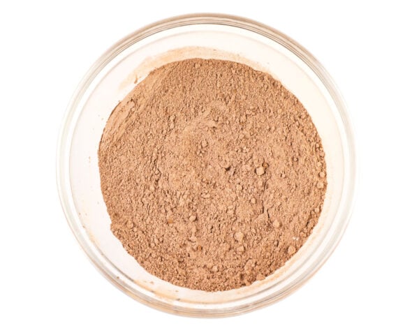 Cocoa powder has been mixed with flour and other dry ingredients and sits in the bottom of a glass mixing bowl.