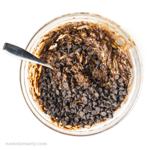 A bowl of chocolate cake batter also has chocolate chips in it.