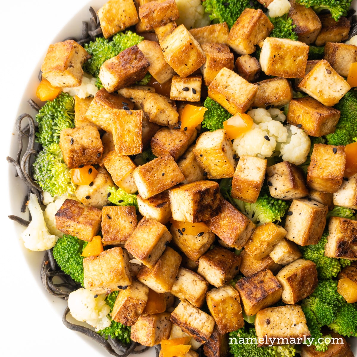 Looking down on cooked tofu over noodles.