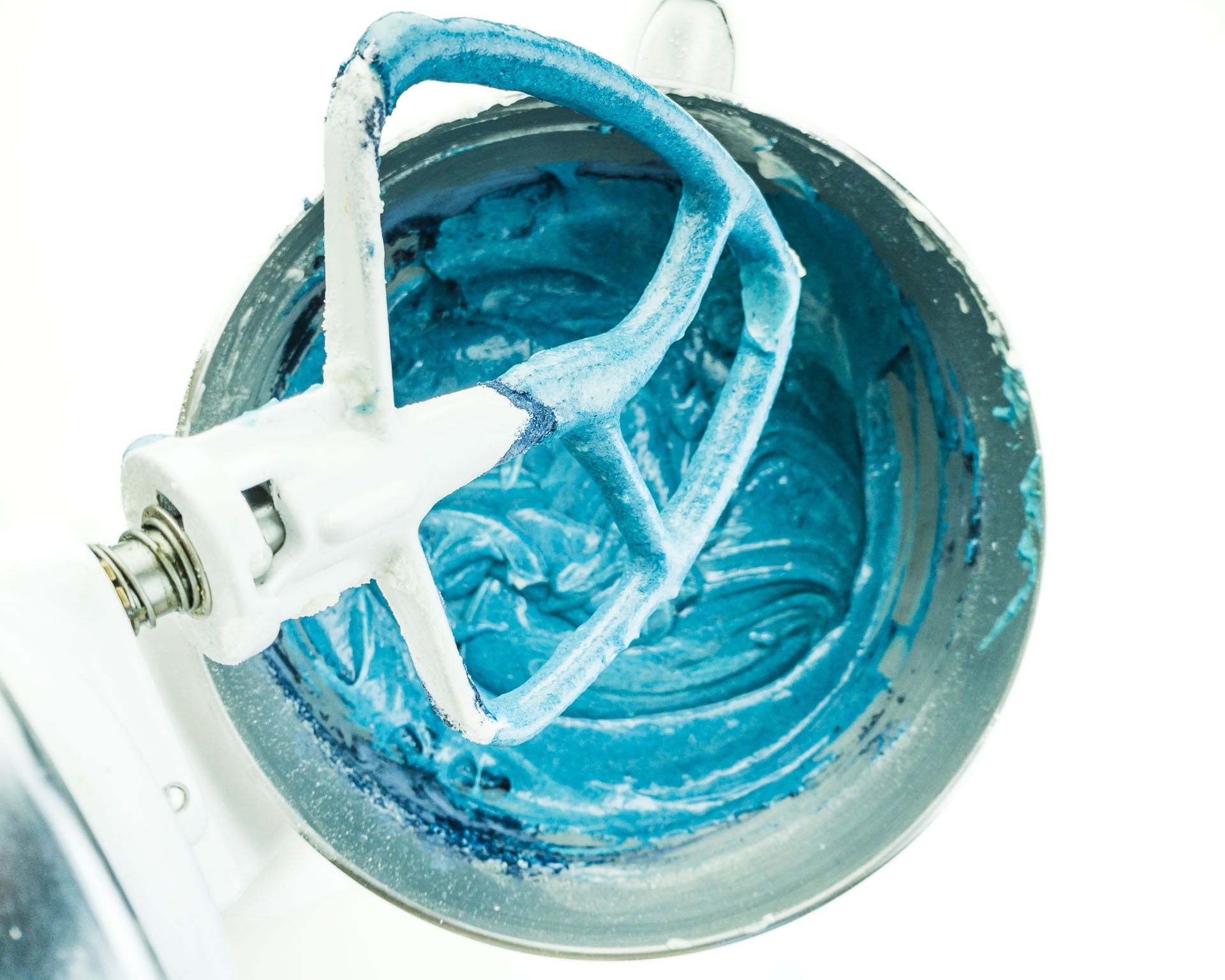 Blue cake batter in a mixing bowl of a stand mixer.