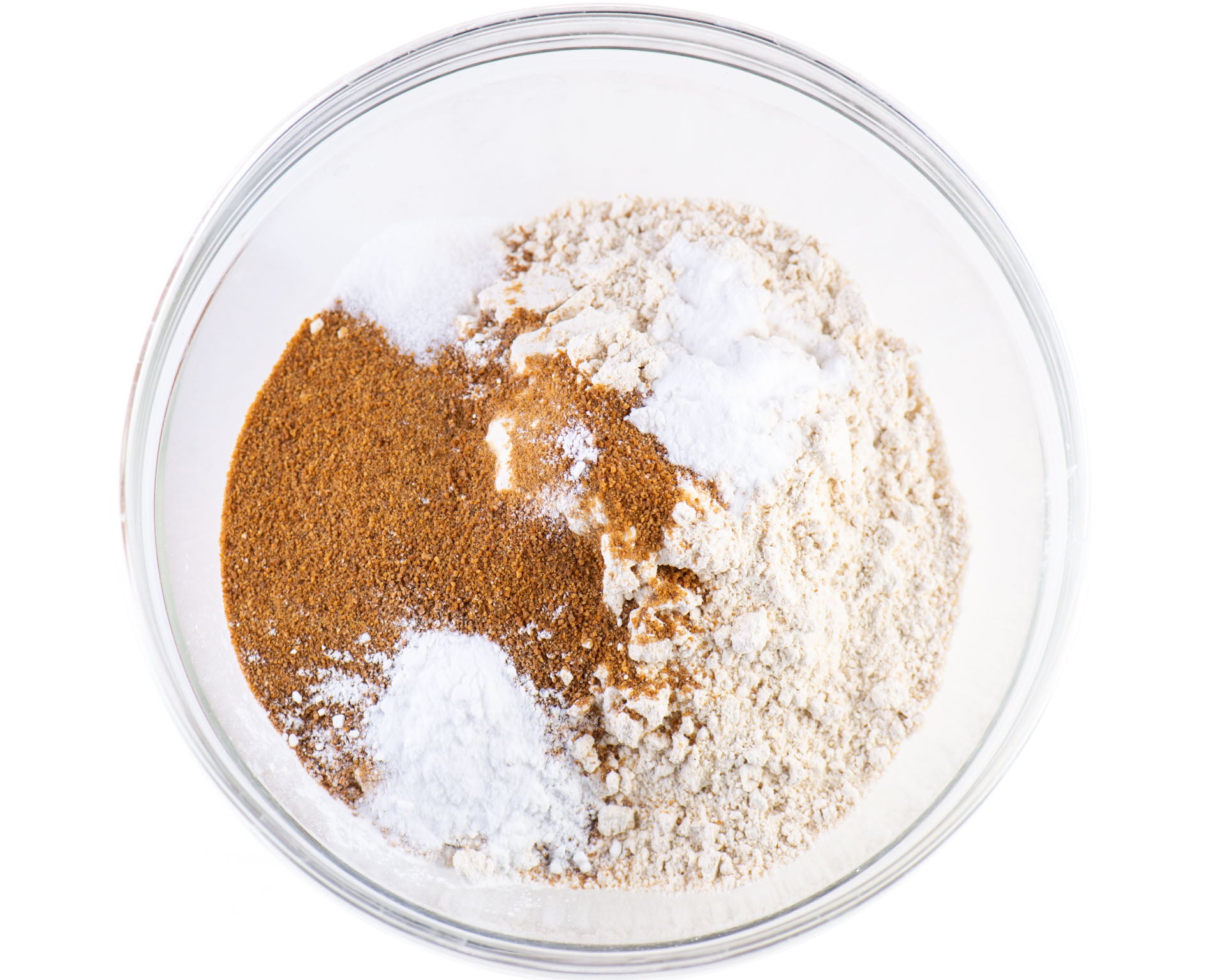 Flour, coconut sugar, and other dry ingredients for banana muffins in a bowl.