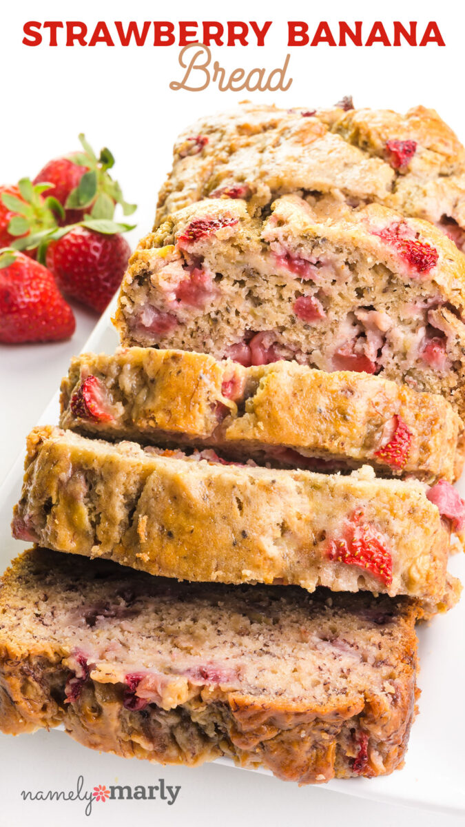 Sliced strawberry banana bread on a white plate with fresh strawberries in the background.