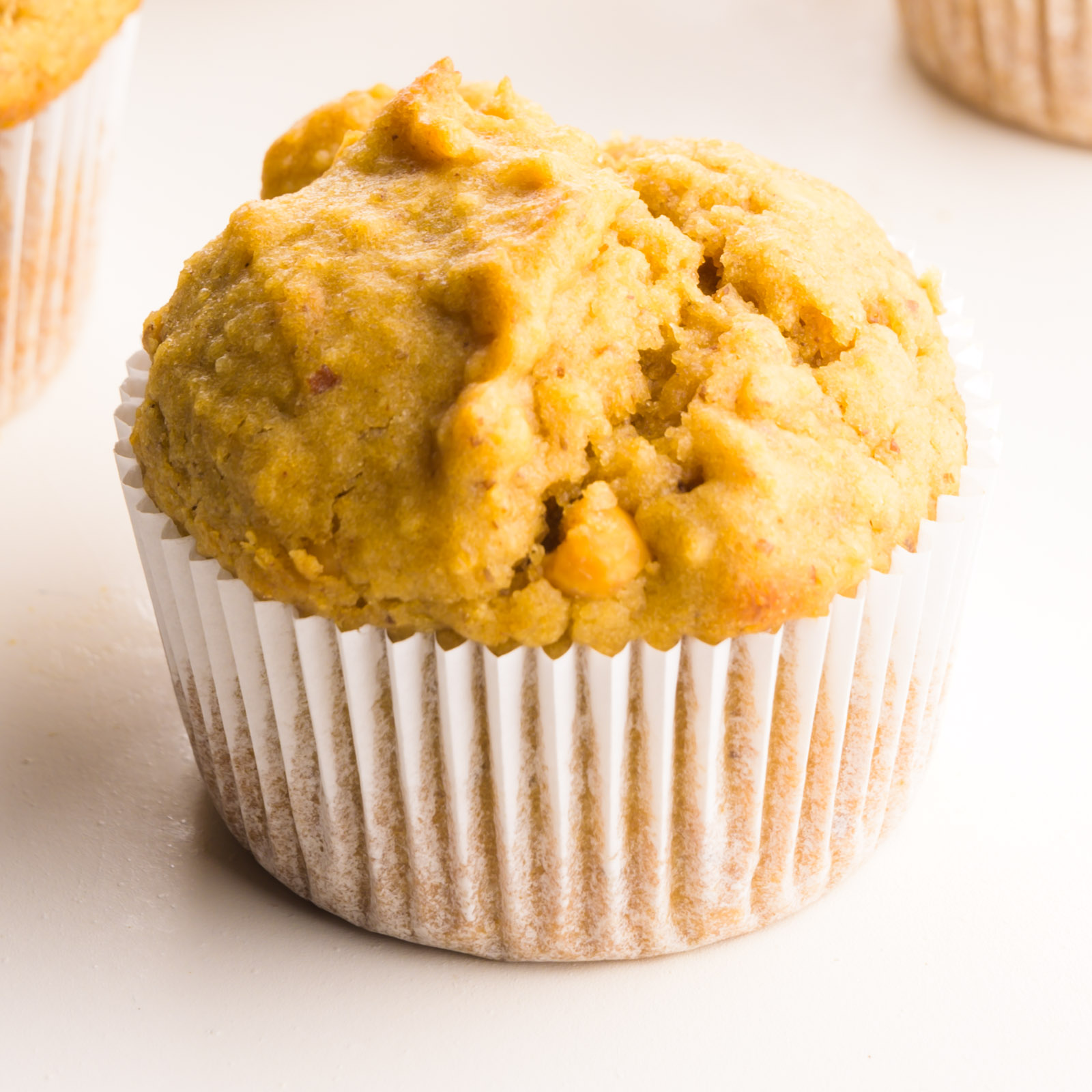 A peanut butter muffin has several muffins around it.