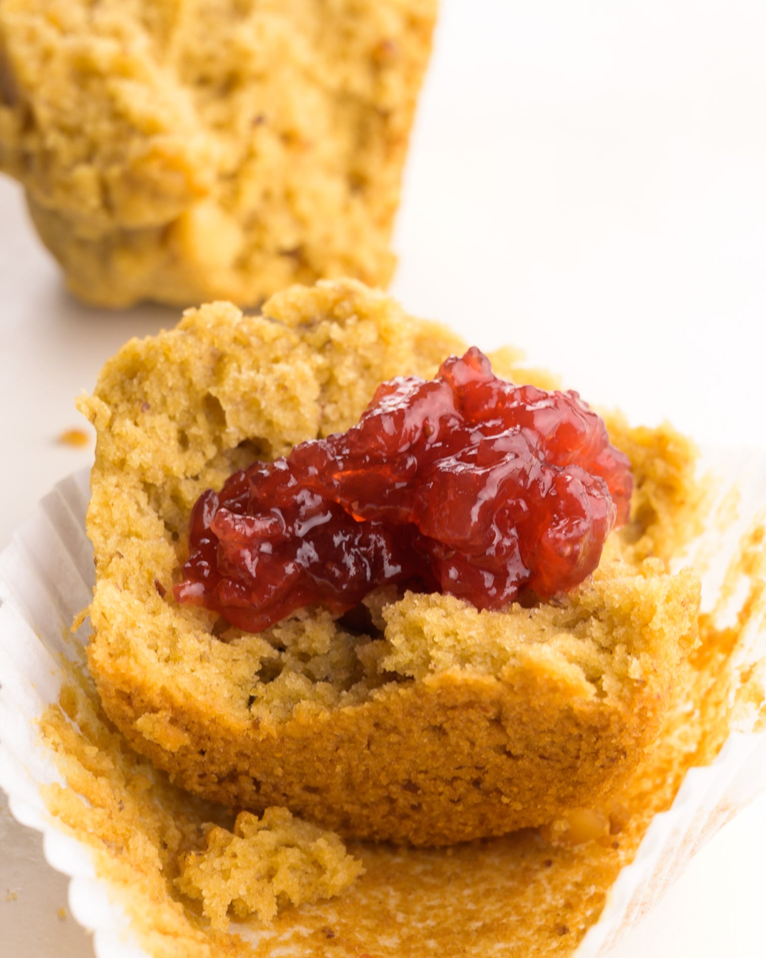 Jelly has been smeared over a half of a muffin.