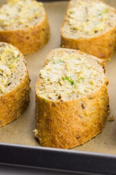 A close-up of several slices of bread topped with vegan butter.