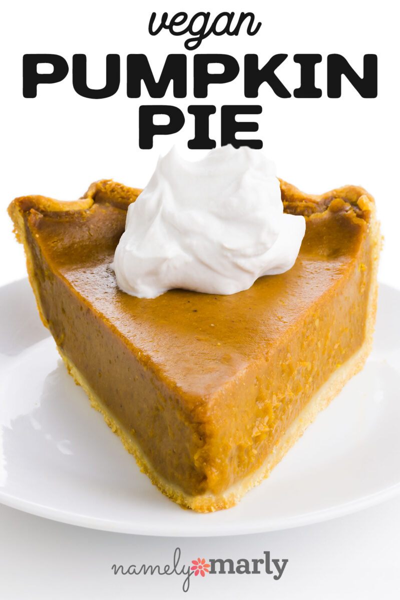 Slice of vegan pumpkin pie topped with whipped cream on a white plate.